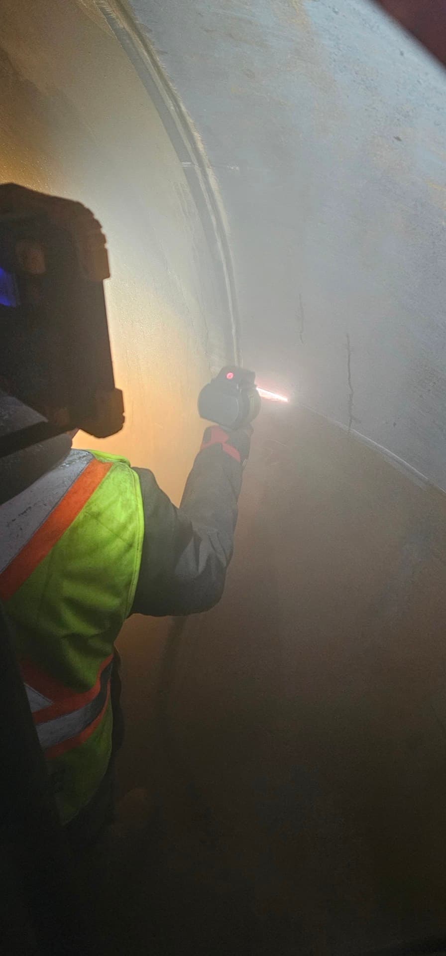 Empower Nuclear operator performing laser ablation decontamination inside an industrial vessel